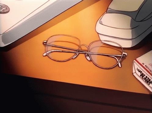 A Pair Of Glasses Sits On A Table Next To A Box Of Cigarettes GIF
