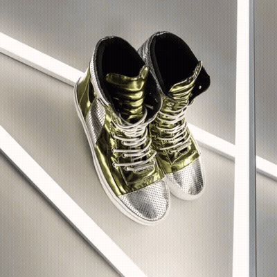 A Pair Of Gold And Silver High Top Sneakers Are Sitting On A White Surface GIF