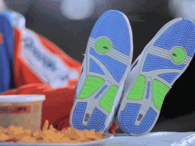 A Pair Of Reebok Shoes Are Laying On A Table Next To A Plate Of French Fries GIF