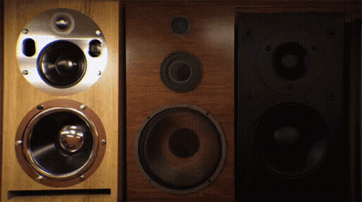 A Pair Of Speakers Sitting Next To Each Other On A Dark Background GIF