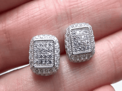 A Pair Of Square Shaped Stud Earrings Are Being Held In Someone 'S Hand GIF