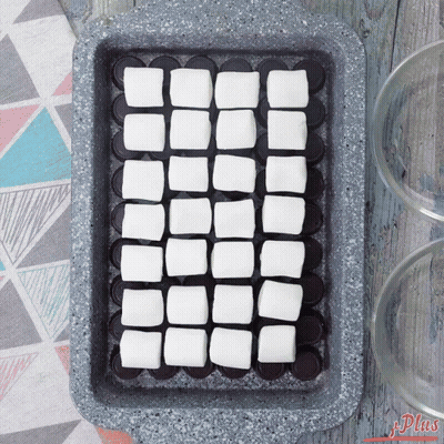 A Pan Filled With Squares Of Marshmallows On Top Of Chocolate Covered Oreos GIF