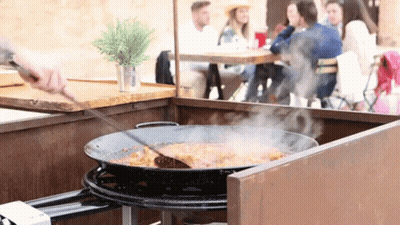 A Pan Of Food Is Being Stirred By A Person GIF