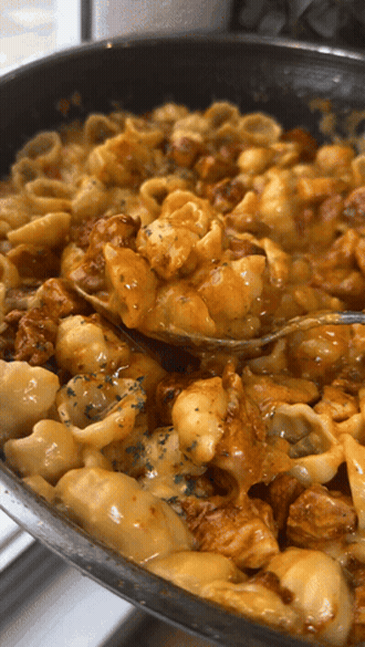 A Pan Of Macaroni And Cheese With A Fork In It GIF
