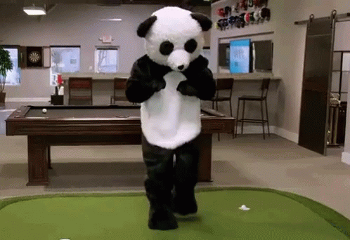 A Panda Bear Mascot Is Standing On A Green Putting Green In Front Of A Pool Table GIF