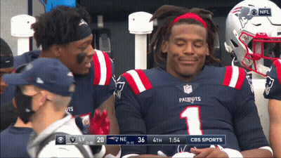 A Patriots Football Player Is Smiling While Sitting On The Bench GIF
