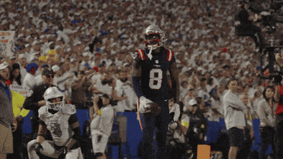 A Patriots Player With The Number 8 On His Jersey Stands In Front Of A Crowd GIF