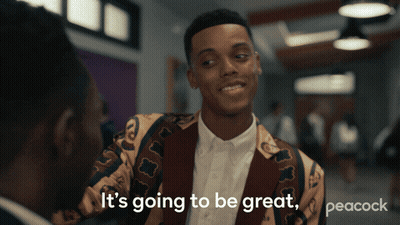 A Peacock Ad Shows A Man In A Colorful Jacket Talking To Another Man GIF