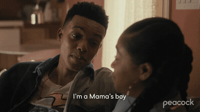 A Peacock Ad Shows A Man Talking To A Woman Who Says I 'M A Mama 'S Boy GIF