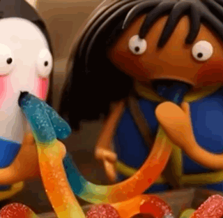 A Penguin And A Girl Are Eating Gummy Worms Together . GIF