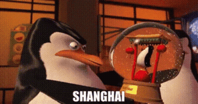 A Penguin Is Holding A Snow Globe With The Word Shanghai Written On It . GIF