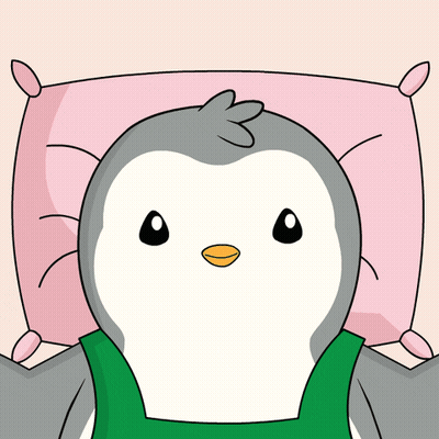 A Penguin Is Laying On A Pink Pillow With A Green Shirt On GIF