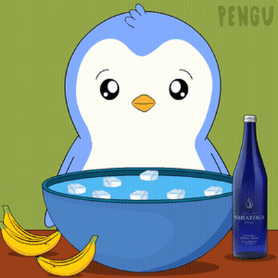 A Penguin Is Sitting Next To A Bowl Of Ice And Bananas GIF
