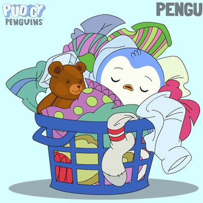 A Penguin Is Sleeping In A Laundry Basket With Clothes And A Teddy Bear GIF