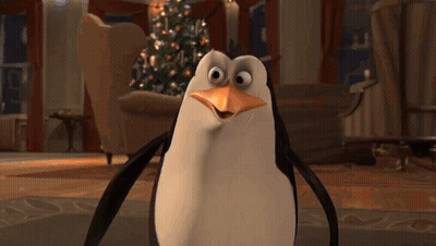 A Penguin Is Standing In Front Of A Christmas Tree In A Living Room GIF