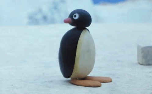 A Penguin Made Out Of A Piece Of Ice Is Standing On The Snow . GIF