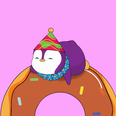 A Penguin Wearing A Party Hat Is Laying On Top Of A Doughnut GIF