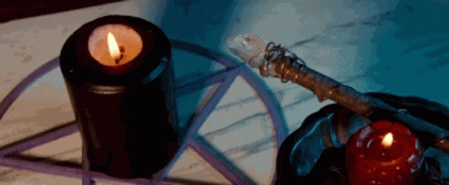 A Pentagram Is Surrounded By Candles And A Wand GIF
