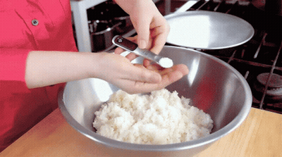 A Person Adding Salt To A Bowl Of Rice GIF