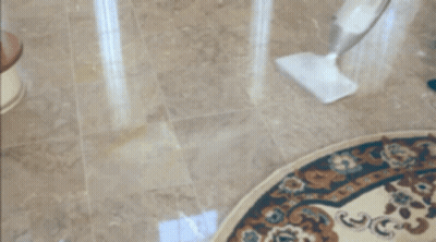 A Person Cleaning A Rug With A Mop On The Floor GIF