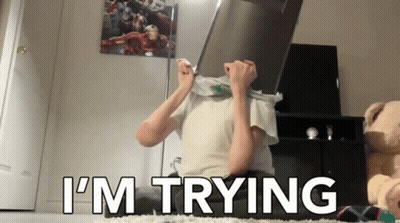 A Person Covering Their Face With A Box And The Words I 'M Trying GIF