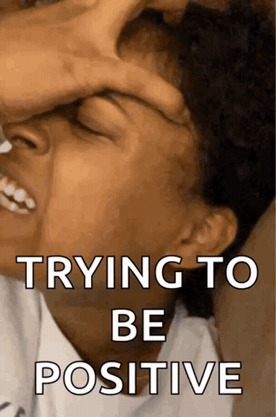 A Person Covering Their Face With Their Hand And The Words Trying To Be Positive On The Bottom GIF