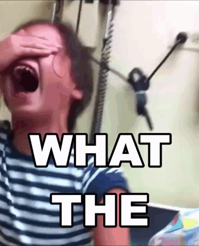 A Person Covering Their Face With Their Hand And The Words " What The " Written Above Them GIF