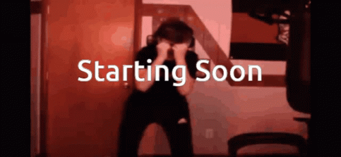 A Person Covering Their Face With Their Hands In Front Of A Sign That Says " Starting Soon " GIF
