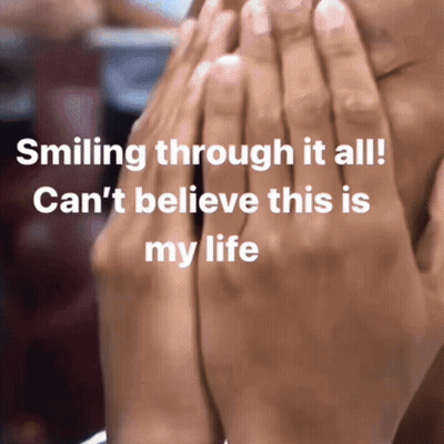 A Person Covering Their Face With Their Hands With The Words Smiling Through It All GIF