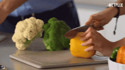 A Person Cutting Vegetables On A Cutting Board With Netflix Written On The Bottom GIF