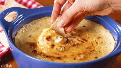 A Person Dipping A Tortilla Chip Into A Bowl Of Dip With The Word Delish On The Bottom GIF