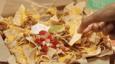 A Person Dipping A Tortilla Chip Into A Box Of Nachos GIF