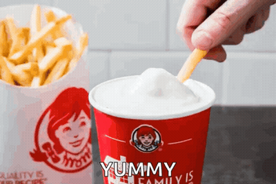A Person Dipping French Fries Into A Wendy 'S Drink GIF