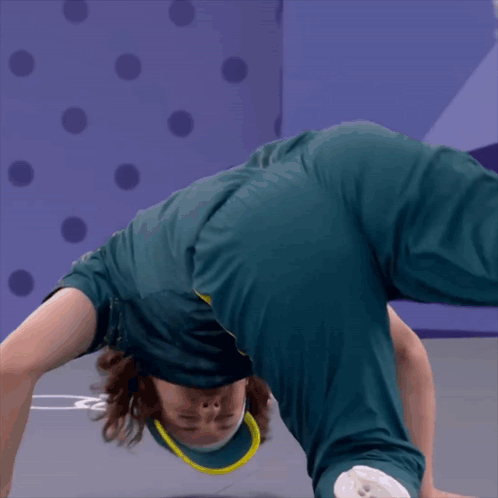 A Person Doing A Handstand In Front Of A Purple Background GIF