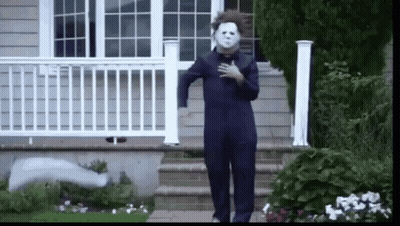 A Person Dressed As Michael Myers Is Walking Down A Set Of Stairs . GIF