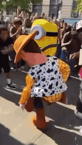 A Person Dressed As Woody From Toy Story And A Minion Is Dancing In Front Of A Crowd . GIF