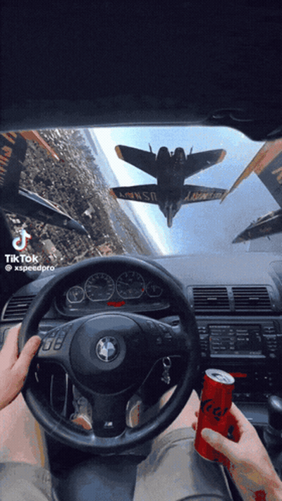 A Person Driving A Car With A Can Of Soda In Front Of Them GIF