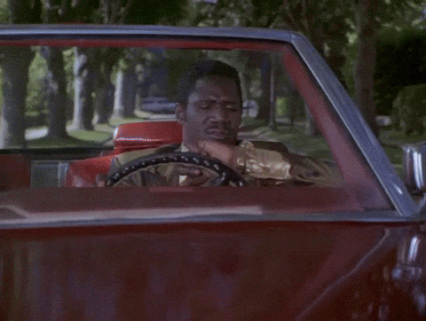 A Person Driving Down A Street With A Red Stop Sign GIF