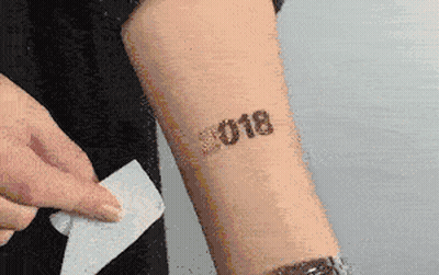 A Person Has A Tattoo On Their Arm That Says ' 2018 ' GIF