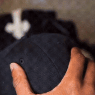 A Person Holding A Black Hat With An Arrow Pointing Up GIF