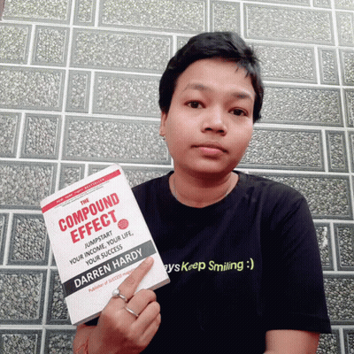 A Person Holding A Book Titled Compound Effect By Darren Hardy GIF