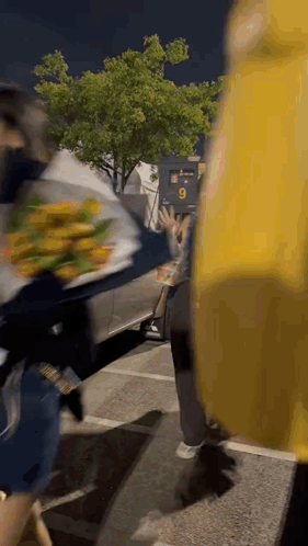A Person Holding A Bouquet Of Flowers In A Parking Lot . GIF