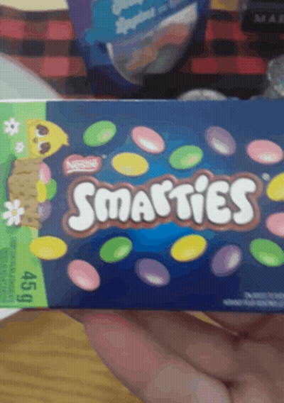 A Person Holding A Box Of Smarties Candy GIF