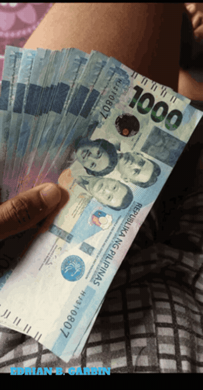 A Person Holding A Fan Of 1000 Peso Bills GIF