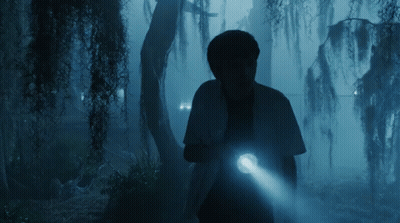 A Person Holding A Flashlight In The Dark GIF