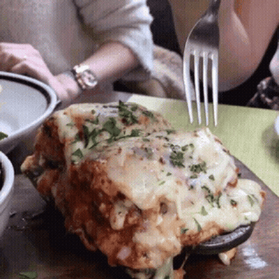 A Person Holding A Fork Over A Piece Of Food GIF