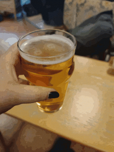 A Person Holding A Glass Of Beer With Black Nails GIF