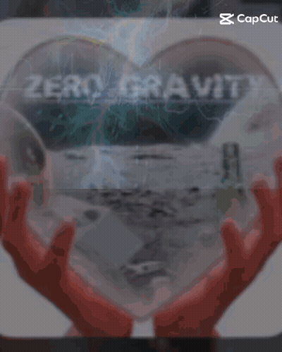 A Person Holding A Heart Shaped Object With The Word Zero Gravity On It GIF