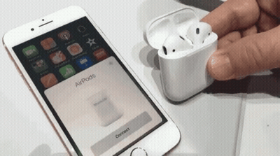 A Person Holding A Pair Of Airpods Next To A Phone That Says Connect GIF