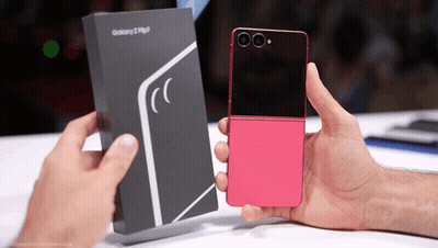A Person Holding A Pink Flip Phone Next To A Box That Says Galaxy GIF